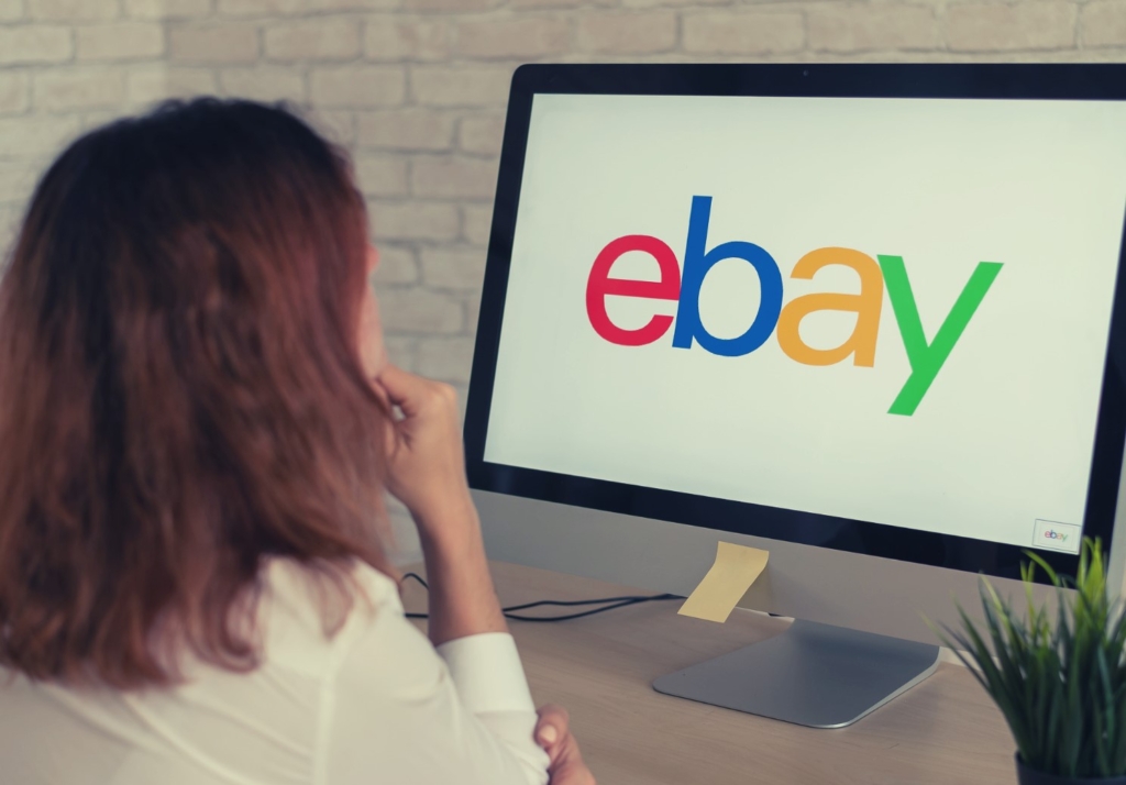 Mujer buscando eBay vendiendo herramientas en una computadora.