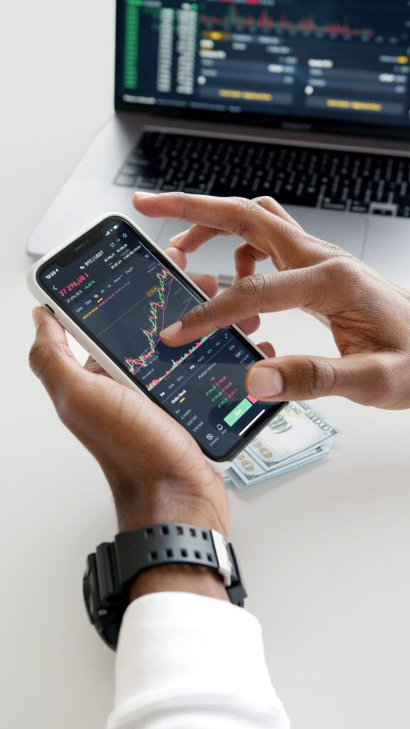 ChatGPT para comerciantes e inversores: una pantalla móvil y una computadora portátil que muestran algunas tendencias del mercado de valores